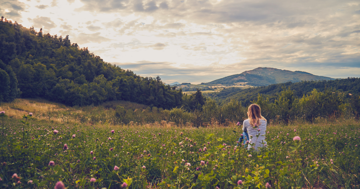 A woman sitting in a valley of flowers