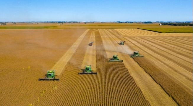 six large row crop tractors on crop field