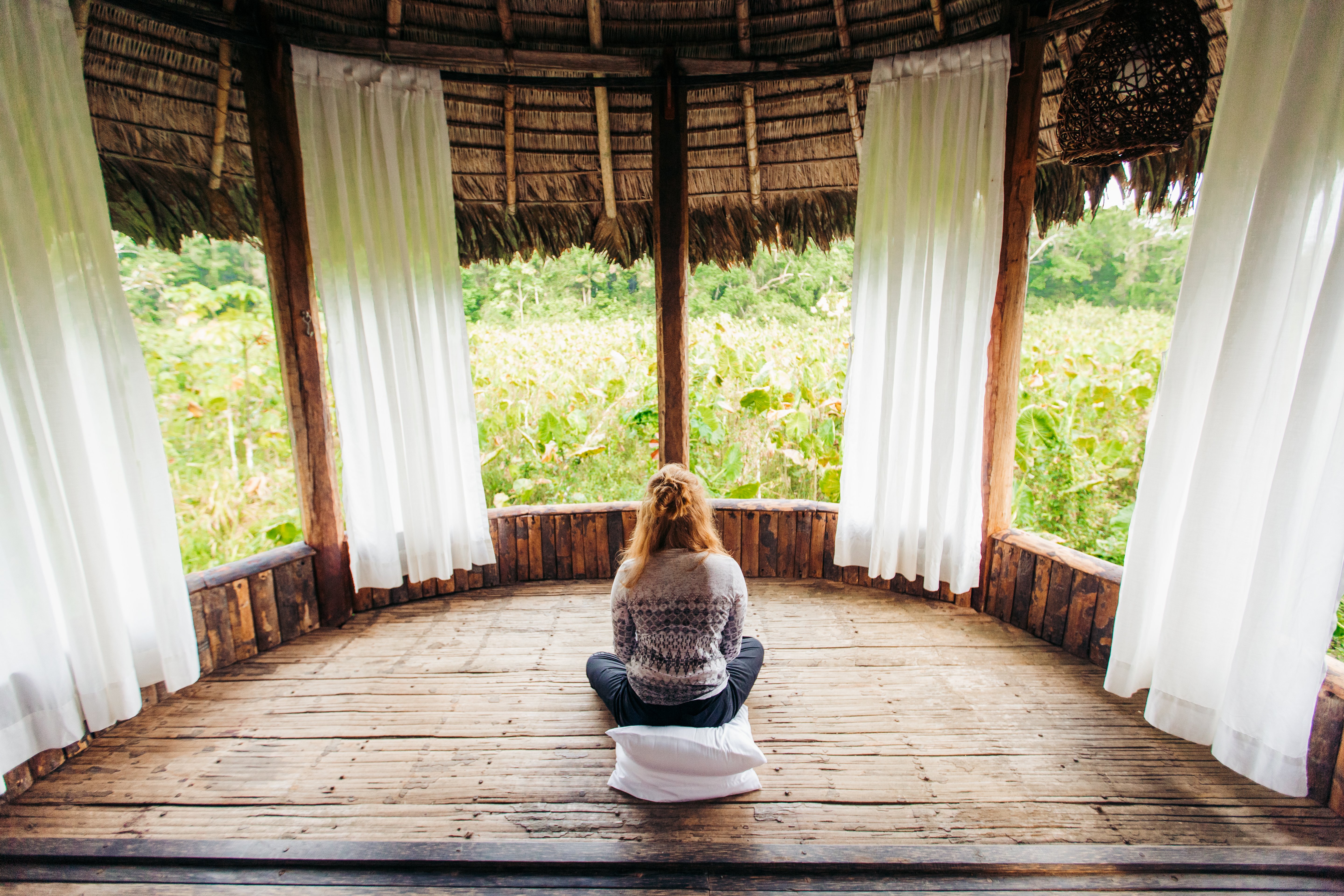 person sitting on ground looking outside at kapawi ecolodge