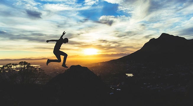 person jumping with sunset in background